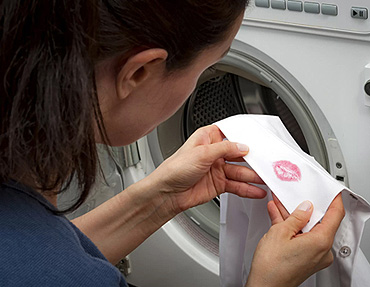 Private investigator examining clothing for evidence of infidelity as part of domestic investigation services by Blue Falcons Investigation